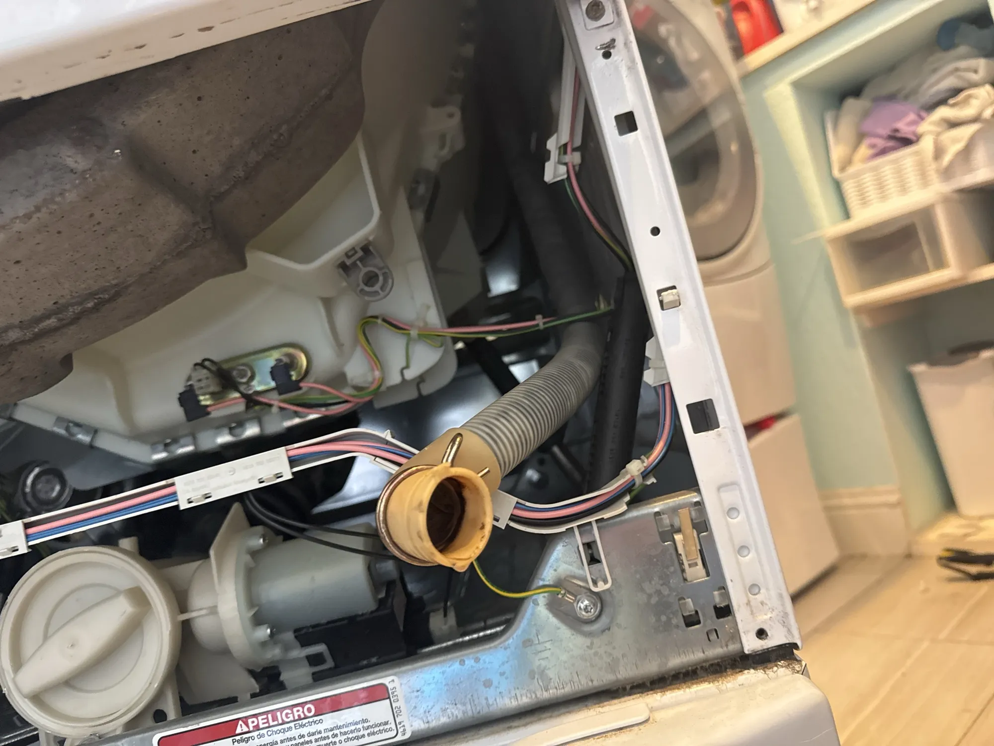 Our Whirlpool washer with the front panel off, the drain hose disconnected and the drain pump below it